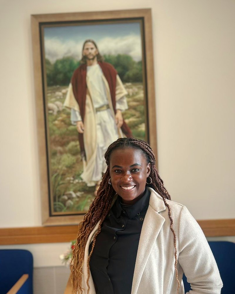 Beatriz Baptista, autora do curso, a sorrir em frente a um quadro do Bom Pastor